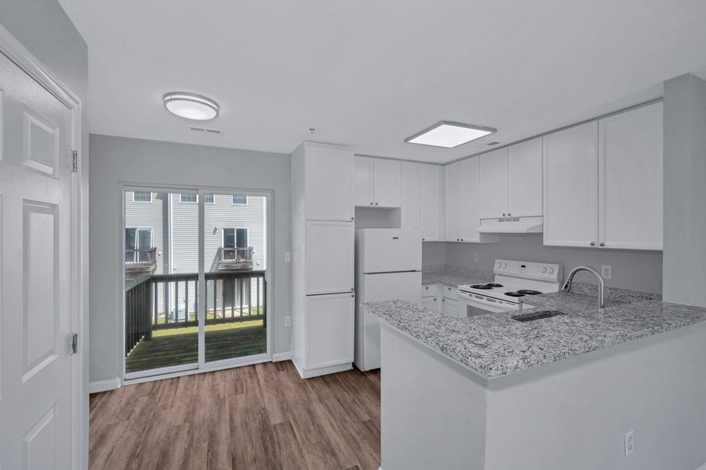 a kitchen with an island and a door to a balcony